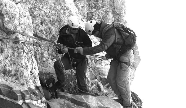 Dave Angus coaches another man on the way down a mountain